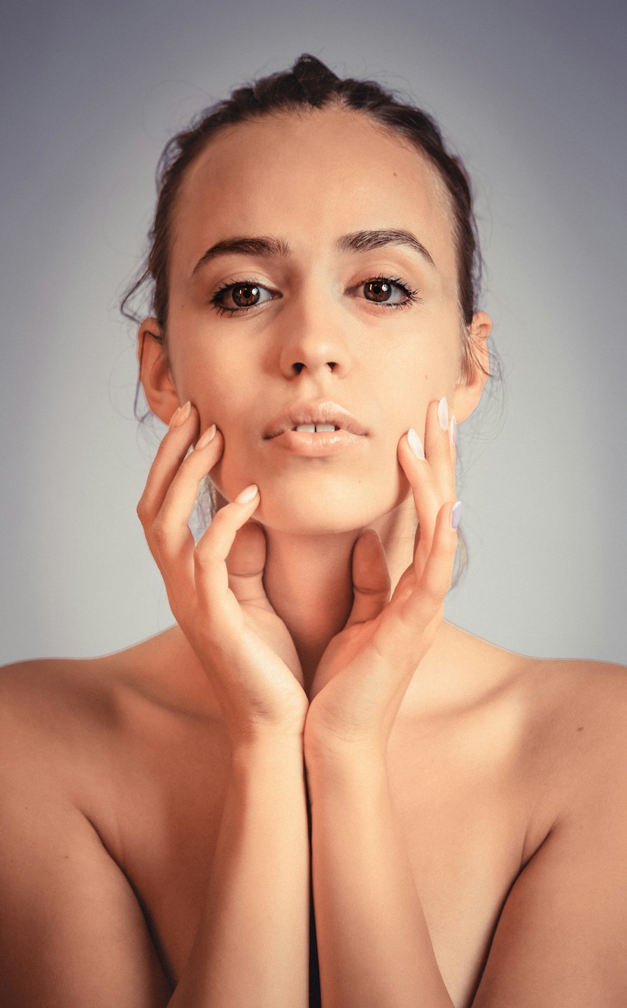 Woman gently cupping her face with both hands.